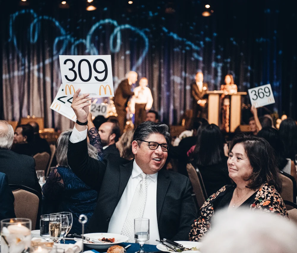 eventgoer holding up auction sign in attempt to bid on auction item